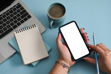 Grafiksel görüntü montajı için cep telefonu beyaz ekranını tutan el kamerası kadın modeli.