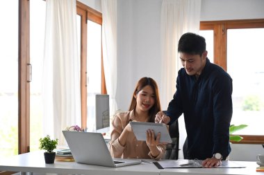 Yakışıklı işadamı dijital tableti işaret ederek iş planlarını meslektaşlarına anlatıyor.