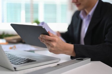 Mimari planda çalışan ve ofis masasında dijital kullanan görünümü kapat.