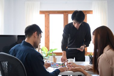 Ofiste beyin fırtınası yapan ve iş planlarını paylaşan bir grup yaratıcı insan..