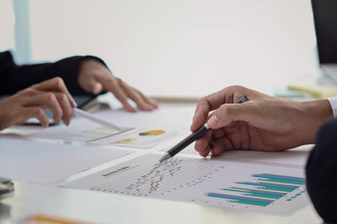 Ofis masasında birlikte grafik analizi yapan finansal danışman grubunu kapat.