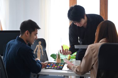 Genç yaratıcı tasarımcı, konferans odasında ortaklarına proje hakkında yeni fikirler veriyor..