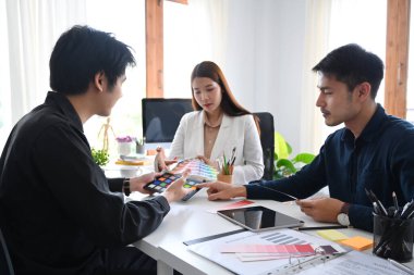 Modern ofisteki müşteriler veya yatırımcılar için yeni proje sunumu hazırlayan yaratıcı tasarımcı grubu.