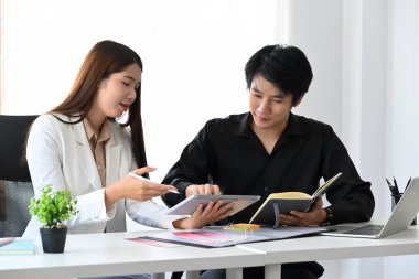 Meslektaşlarıyla yeni proje ve üretken strateji üzerine tartışan profesyonel tasarımcı.