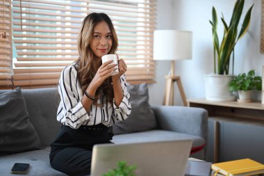 Evdeki kanepede oturup sabahları kahve içen güzel bir kadın..