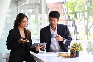 İki başarılı iş adamı modern ofiste iş konularını tartışıyor..