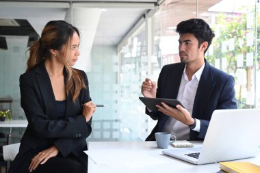 Dijital tablet tutan ve proje detaylarını meslektaşına açıklayan kendine güvenen bir işadamı.