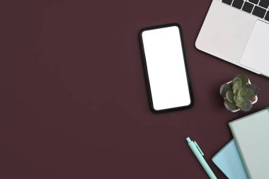 Üst görünüm akıllı telefon, dizüstü bilgisayar, defter ve kaktüs mor arka planda..