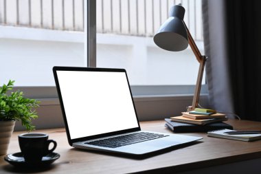 Laptop, kahve fincanı, malzeme ve diğer malzemelerle ahşap masa üzerinde yaratıcı tasarımcı.