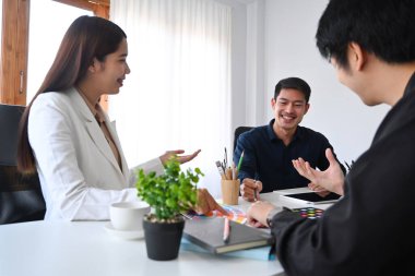 Bir grup iç mimar beyin fırtınası yapıyor, yeni proje üzerinde tartışıyorlar..