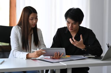 İç mimar ekibi yeni fikirleri paylaşıyor, pazarlama stratejisini modern ofiste birlikte tartışıyorlar..