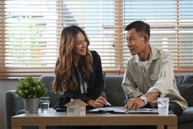 Yaşlı adam mali danışmanla görüşüyor ve gelecekteki mülk satın alma sözleşmesi şartlarını tartışıyor.