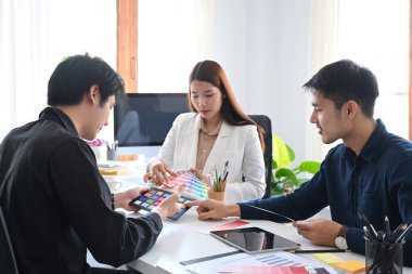 İç mimarlardan oluşan bir ekip, yaratıcı ofiste yeni projeler üzerinde çalışıyor ve beyin fırtınası yapıyor..