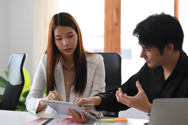 İki yaratıcı insan fikir paylaşıyor ve yaratıcı ofiste renk tasarımı hakkında tartışıyorlar..