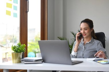 Milenyum güzeli iş kadını iş ortağıyla cep telefonundan konuşuyor..
