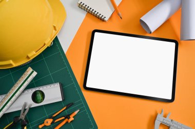 Mimarlık işyerindeki dijital tablet, miğfer, planlar ve mekanik araçlar, Üst Görünüm.