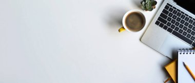 Bilgisayarı, kahve fincanı ve defteri olan beyaz ofis masası. Boşluğu kopyala.