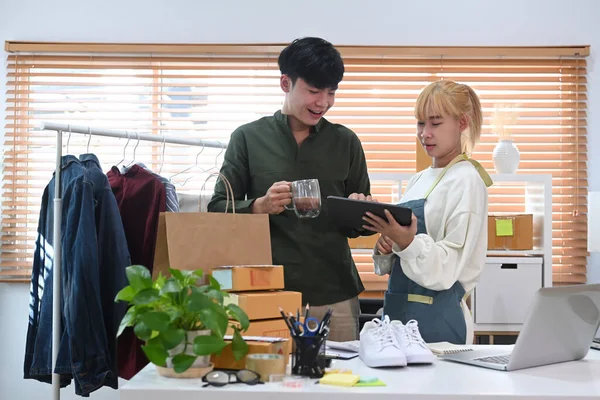 Kontrol eden genç iş adamları, dijital tabletteki müşterilerden sipariş alıyorlar. İnternet üzerinden alışveriş veya çevrimiçi konsept satıyorlar.