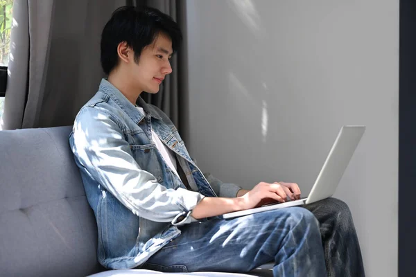 Millennial Asiatico Uomo Riposo Divano Navigazione Internet Con Computer Portatile — Foto Stock