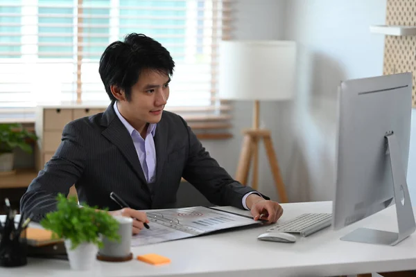 スタイリッシュなオフィスで働く黒のスーツで成功したアジアのビジネスマン — ストック写真