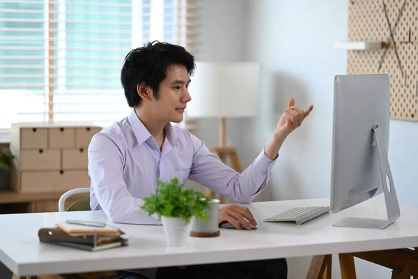 アジア人男性が自宅で働き ビデオ会議を通じて新しいビジネス戦略を説明する — ストック写真