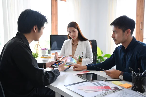 Modern ofisteki müşteriler veya yatırımcılar için yeni proje sunumu hazırlayan yaratıcı tasarımcı grubu.