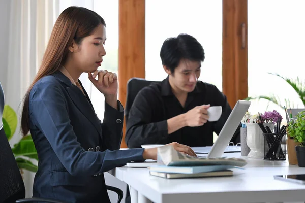Şirket toplantısında dizüstü bilgisayar kullanan Asyalı iş kadını..