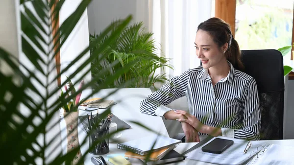 Güzel kadın girişimci iş yerindeki dizüstü bilgisayarında webinar izliyor..