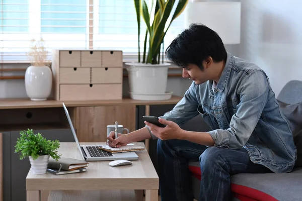 Giovane Uomo Che Legge Messaggi Testo Sul Suo Smartphone Lavorare — Foto Stock