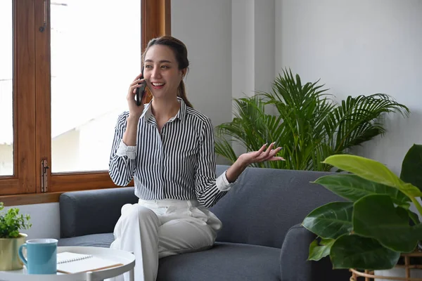Atrakcyjna Młoda Kobieta Rozmawiająca Przez Telefon Podczas Siedzenia Kanapie Domu — Zdjęcie stockowe