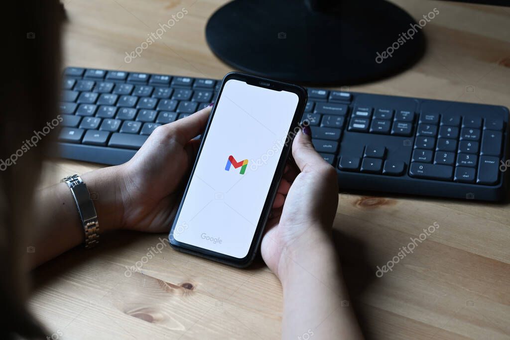 Chiang Mai, Thailand - Mar 01,2022: Woman holding iPhone 11 Pro Max with Gmail app on the screen.Gmail is a free email service provided by Google.