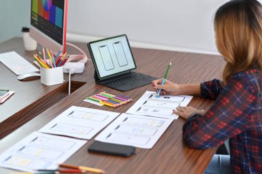 Kadın tasarımcı cep telefonu için uygulama şablonu şeması çiziyor. Kullanıcı deneyimi kavramı.