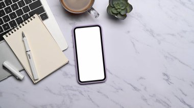 Cep telefonu, dizüstü bilgisayar, kahve fincanı ve not defterini mermer arka plana koyun. Düz yatıyordu.