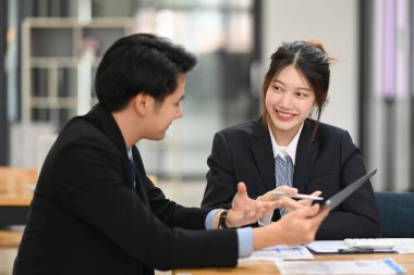 Finansal veri raporlarını birlikte analiz eden başarılı iş adamları