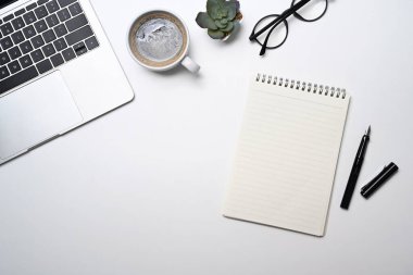 Blank notepad, glasses, coffee cup and laptop computer on white background. Top view