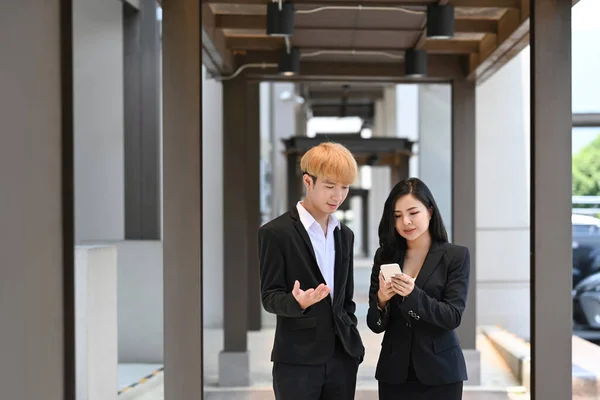 Young businesspeople in suit having a discussion while walking at modern office district — Foto Stock