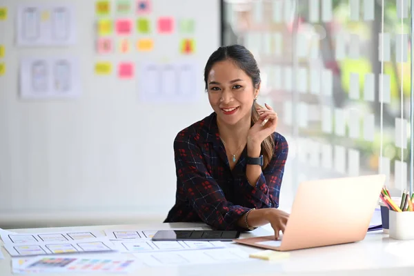 Beautiful creative woman or developer working on user interface design at modern office.