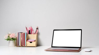 Front view computer laptop, flower pot and stationery on white table