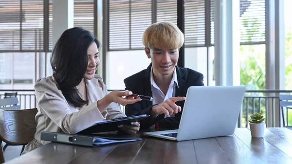 Two young businesspeople using computer laptop and discussing on new startup project together — Foto de Stock