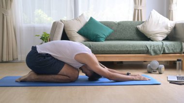 Spor elbiseli genç adam ısınıyor, sabah antrenmanından önce ısınıyor.