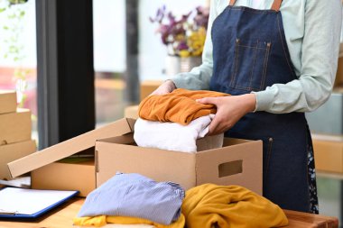 Start up business entrepreneur checking order before sending, packing product in cardboard box for delivery