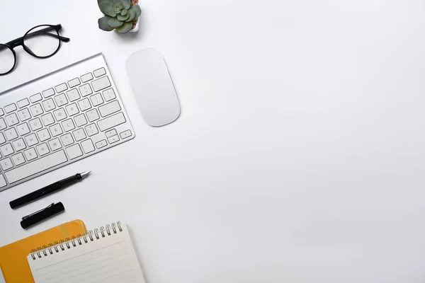 Escritorio de oficina blanco de vista superior con teclado inalámbrico, gafas, portátil y planta suculenta — Foto de Stock