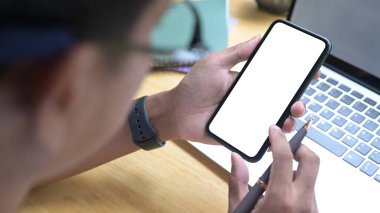 Bilgisayarın önünde oturan ve cep telefonu kullanan genç adamı kapat.