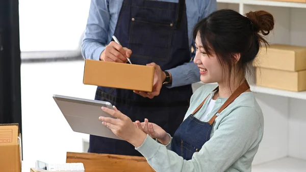 Cheerful young woman working on start up business with her colleague at home office — 스톡 사진