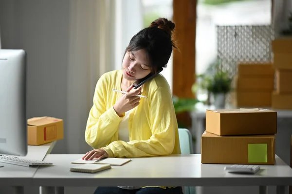 Snímek ženy on-line prodejce pomocí chytrého telefonu pro potvrzení objednávky nebo přijímání objednávek od zákazníka — Stock fotografie