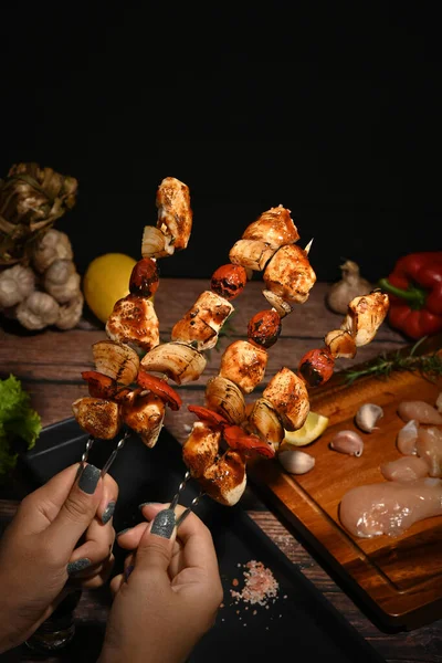 Woman hands holding grilled skewers of chicken, bell peppers, tomatoes, onion. Close up — ストック写真