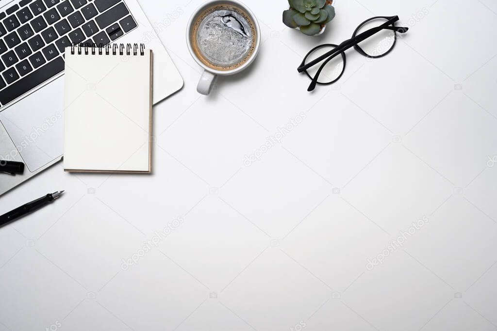 Simple workplace with laptop computer, coffee cup, glasses and notebook. Top view, flat lay, copy space