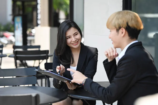 Due colleghi di lavoro che discutono mentre sono seduti in caffetteria all'aperto — Foto Stock