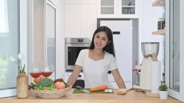 Feliz jovem asiático mulher de pé em casa cozinha e preparar vegetariano refeição — Fotografia de Stock