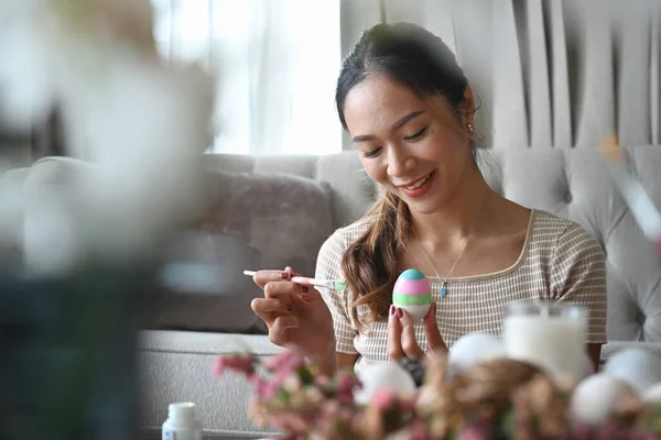 Fiatal csinos nő élvezze színező tojás húsvéti fesztivál. — Stock Fotó